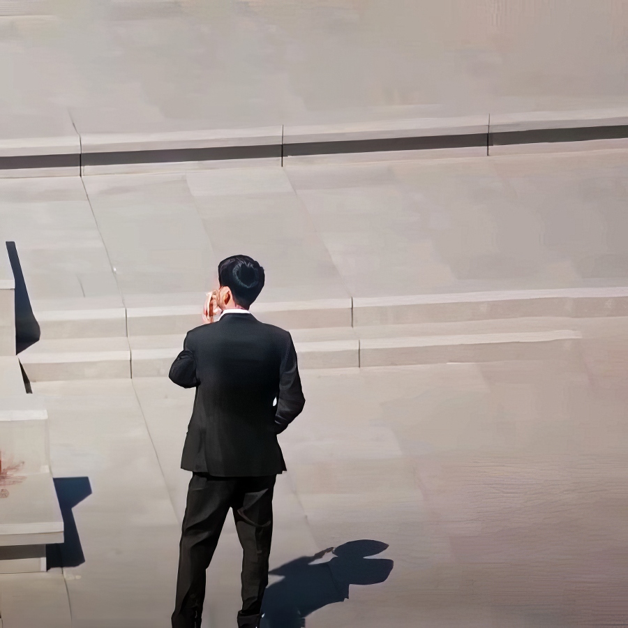 A long shot of a man discontented back facing the camera smoking a cigarette in contemplation